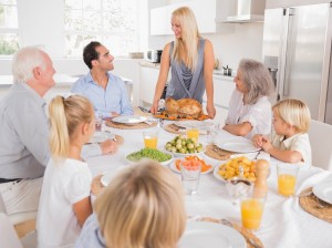 Family looking at the mother with a turkey plate for dinner