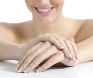 Beautiful woman hands nails with perfect french manicure isolated on a white background