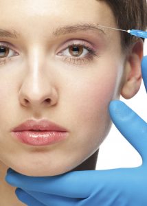 Cosmetic injection of botox to the pretty female face. Isolated on white background