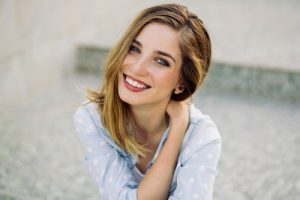 Portrait of a girl with a charming smile sitting on the steps