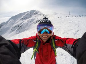 Selfie of cheerful skier on the top of the mountain